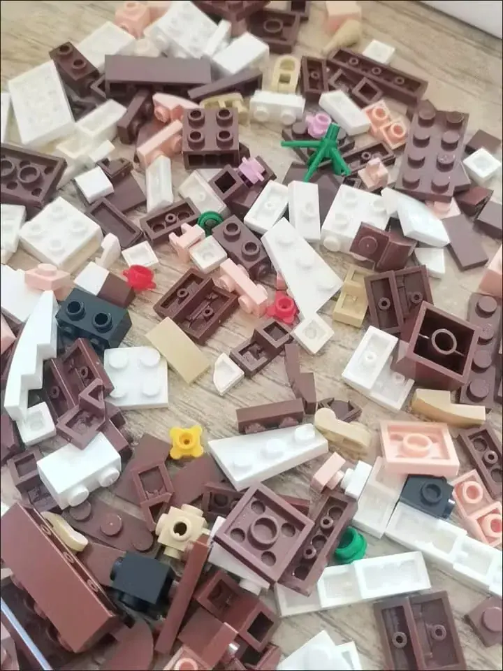 Россыпь деталей конструктора BrickMe в бежево-коричневой гамме перед сборкой фигурки